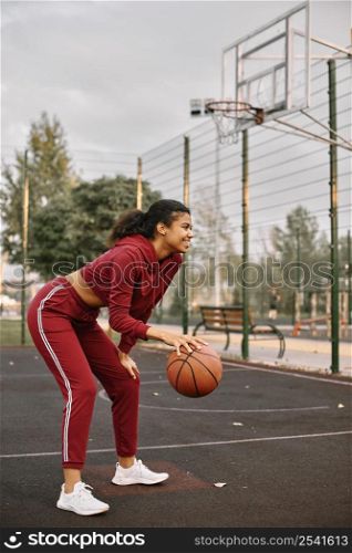 black american woman playing basketball field