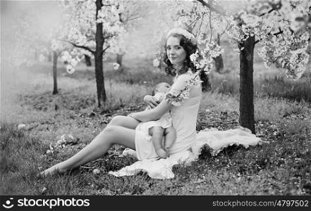 Black&amp;white portrait of a mother feeding a baby in the garden