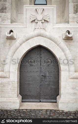 black ancient metallic door in old stone wall