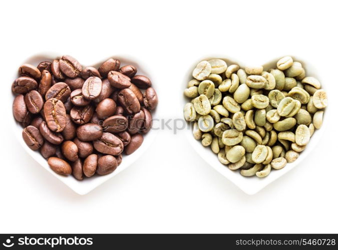 Black and green coffee beans in the heart shape bowls on white