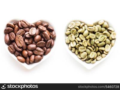 Black and green coffee beans in the heart shape bowls on white