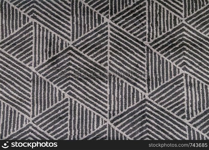 Black and grey carpet with hand made geometric pattern.