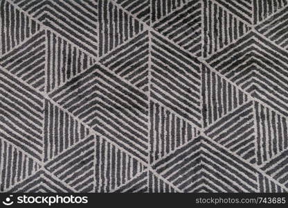 Black and grey carpet with hand made geometric pattern.