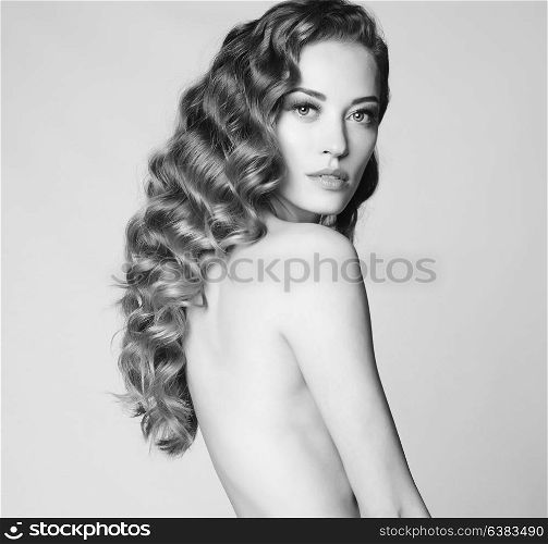 Black and white art portrait of sensual nude woman with elegant hairstyle on gray background