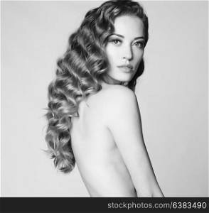 Black and white art portrait of sensual nude woman with elegant hairstyle on gray background