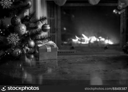 Black and white background with wooden table in front of burning fireplace and Christmas tree