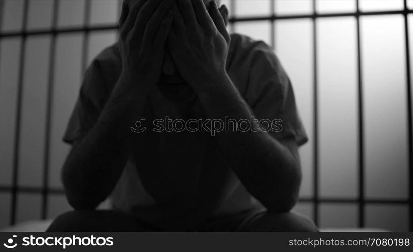 Black and white Backlit scene of a depressed inmate in prison