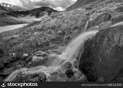 Black and white Beautiful landscape image of stream near Llyn Ogwen in Snowdonia during early Autumn flowing towards Tryfan in background