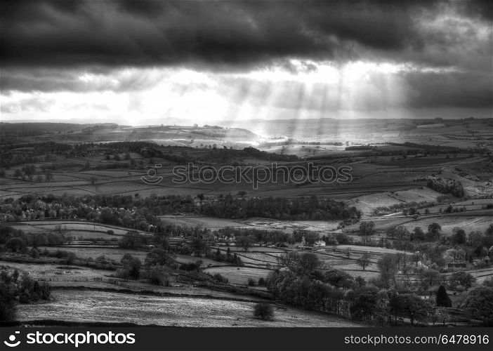 Black and white beautiful sunbeams over Big Moor in the Peak Dis. England, Derbyshire, Curbar Edge. Sunbeams over Big Moor in the Peak District in Autumn.. Stunning black and white sunbeams over Big Moor in the Peak District landscape in Autumn