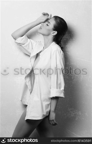 black and white , beautiful woman with brown hair and perfect skin in fashion pose with unbuttoned white shirt and nude legs