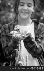 Black and white closeup image of smiling teenage girl holding ripe white in hands. Black and white closeup photo of smiling teenage girl holding ripe white in hands