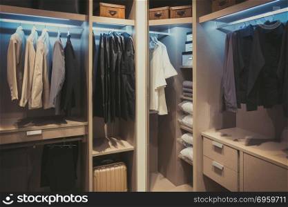 Black and white cloths hanging in wooden wardrobe at home