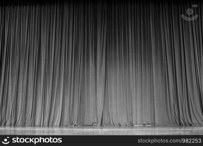 Black and white curtains and the wooden stage in a theater.