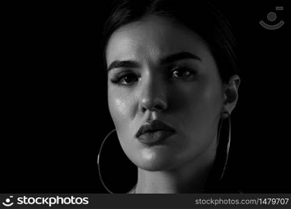 black and white dramatic portrait of a young girl on a black background.