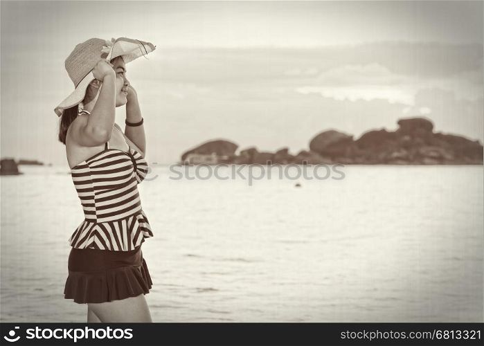 Black and white enhancer tone girl in a swimsuit and hat on the beach during sunrise vintage style at Koh Miang Islands, Mu Ko Similan National Park, Phang Nga, Thailand