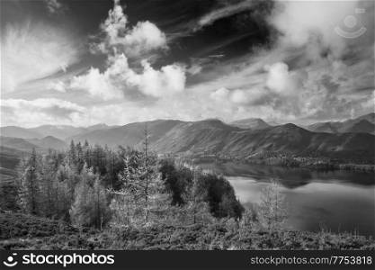 Black and white Epic landscape Autumn image of view from Walla Crag in Lake District, over Derwentwater looking towards Catbells and distant mountains with stunning Fall colors and light