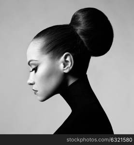 Black and white fashion art studio portrait of beautiful elegant woman in black turtleneck. Hair is collected in high beam. Elegant ballet style