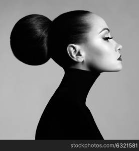 Black and white fashion art studio portrait of beautiful elegant woman in black turtleneck. Hair is collected in high beam. Elegant ballet style