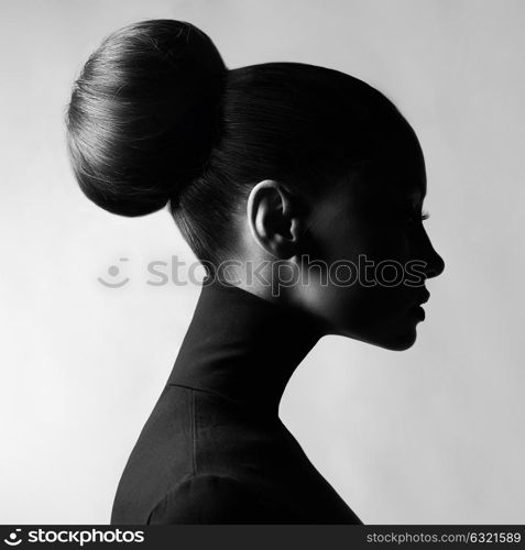 Black and white fashion art studio portrait of beautiful elegant woman in black turtleneck. Hair is collected in high beam. Elegant ballet style