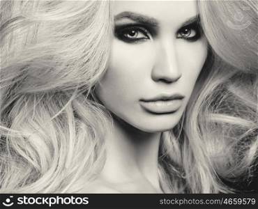 Black and white fashion studio photo of beautiful blonde woman with smoky eyes makeup
