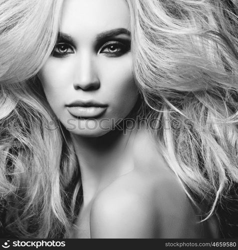 Black and white fashion studio photo of beautiful blonde woman with smoky eyes makeup