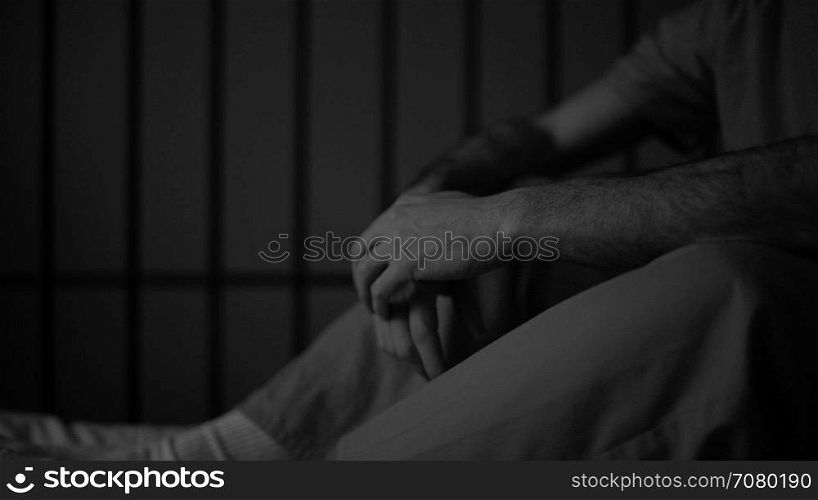 Black and white gloomy scene of an inmate in prison