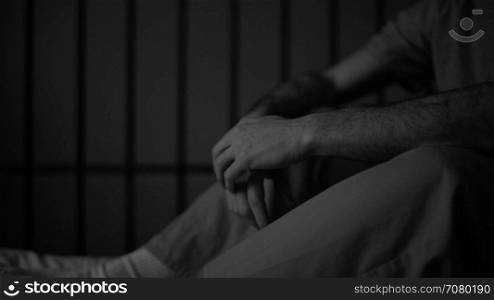 Black and white gloomy scene of an inmate in prison