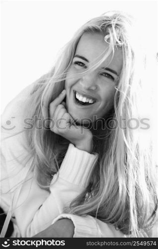 Black and white head and shoulder portrait of pretty blond Caucasian woman smiling and laughing.