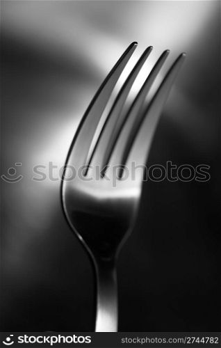 Black and white image of a fork. Very shallow depth-of field, sharpness only in the closest pin.