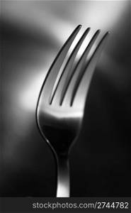 Black and white image of a fork. Very shallow depth-of field, sharpness only in the closest pin.