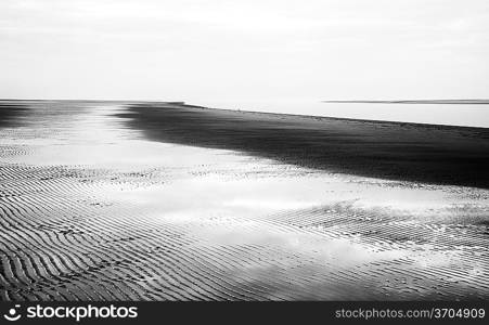 Black and white image of beach at low tide landscape