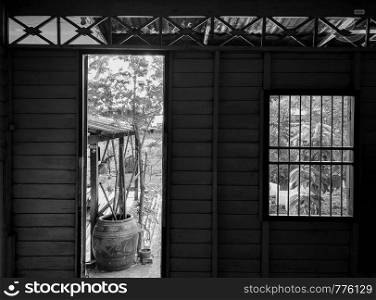 Black and white image of Empty abandoned wooden house in rural asian country with garden view