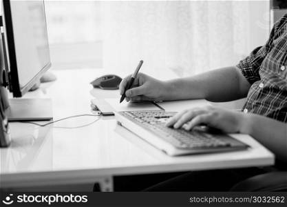Black and white image of male designer using graphic tablet at office. Black and white photo of male designer using graphic tablet at office