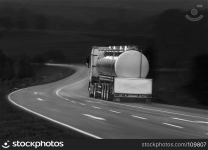 Black and white image with tanker truck driving on a countryside road, outside the german city Schwabisch Hall, Baden Wurttemberg, Germany