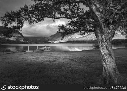 Black and white Landscape image of rowing boats on Llyn Nantlle . Black and white View of rowing boats on Llyn Nantlle in Snowdonia landscape at sunset