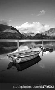 Black and white Landscape image of rowing boats on Llyn Nantlle . Black and white View of rowing boats on Llyn Nantlle in Snowdonia landscape at sunset