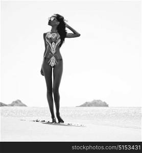 Black and white outdoor fashion photo of beautiful happy slender woman at sea. Beach travel. Summer vibes