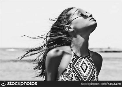 Black and white outdoor fashion photo of beautiful happy woman at sea. Beach travel. Summer vibes