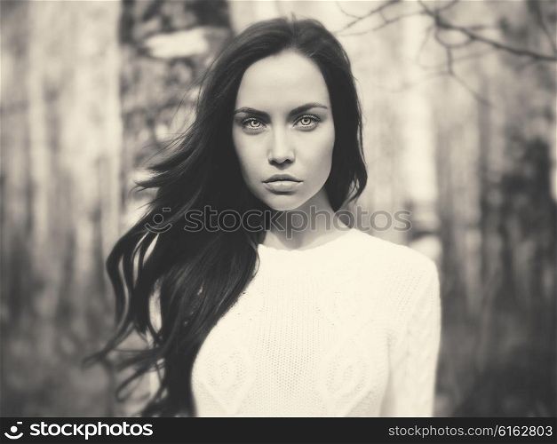 Black and white outdoor fashion photo of young beautiful lady in a birch forest
