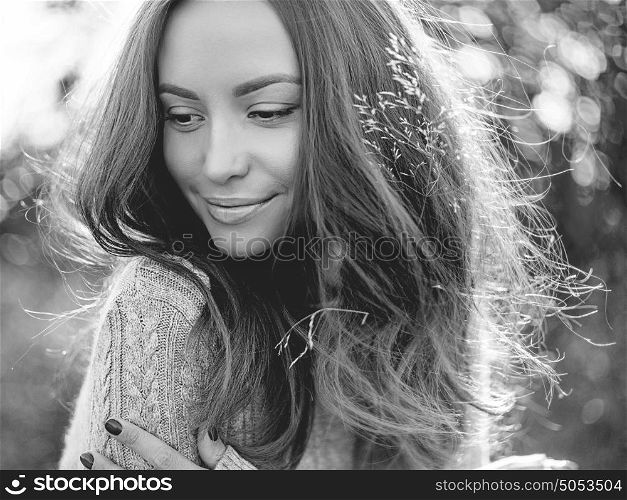 Black and white Outdoor fashion photo of young beautiful lady in autumn landscape with dry flowers. Knitted sweater, wine lipstick. Warm Autumn. Warm Spring