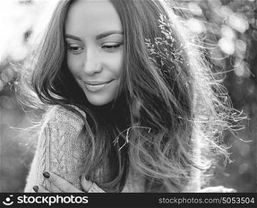 Black and white Outdoor fashion photo of young beautiful lady in autumn landscape with dry flowers. Knitted sweater, wine lipstick. Warm Autumn. Warm Spring