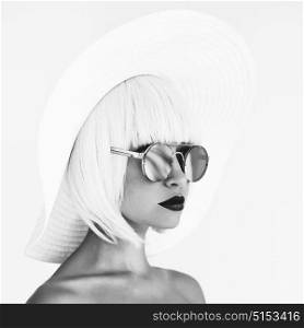 Black and white outdoor fashion photo of young beautiful lady in white hat and mirror sunglasses. Summer Beach travel. Summer vibes