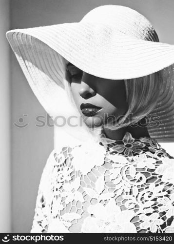 Black and white outdoor fashion photo of young beautiful lady in white hat. Summer Beach travel. Summer vibes