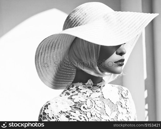 Black and white outdoor fashion photo of young beautiful lady in white hat. Summer Beach travel. Summer vibes