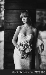 Black and white photo. Bride portrait in white dress with bouquet in hand close up. Bride. Beauty portrait of bride wearing fashion wedding dress with luxury delight make-up and hairstyle. Wedding. Black and white photo. Bride portrait in white dress with bouquet in hand close up. Bride. Beauty portrait of bride wearing fashion wedding dress with luxury delight make-up and hairstyle. Wedding.