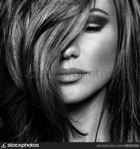 Black and white photo of attractive supermodel with sexy stylish makeup and healthy shiny hair, seductive female on luxury photo shoot