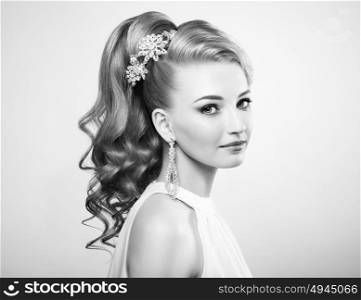 Black and white photo of beautiful woman with elegant hairstyle. Blonde girl with long wavy hair. Perfect make-up. Beauty style woman with diamond accessories
