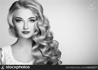 Black and white photo of beautiful woman with elegant hairstyle. Blonde girl with long wavy hair. Perfect make-up. Beauty style model