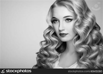 Black and white photo of beautiful woman with elegant hairstyle. Blonde woman with curly hairstyle. Perfect make-up. Fashion photo