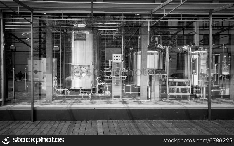 Black and white photo of big cisterns and pipes in brewery